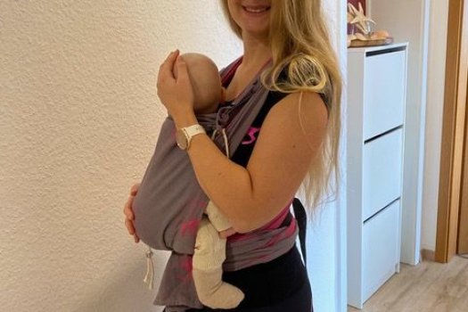 Kangatrainerin mit Baby in Tragehilfe